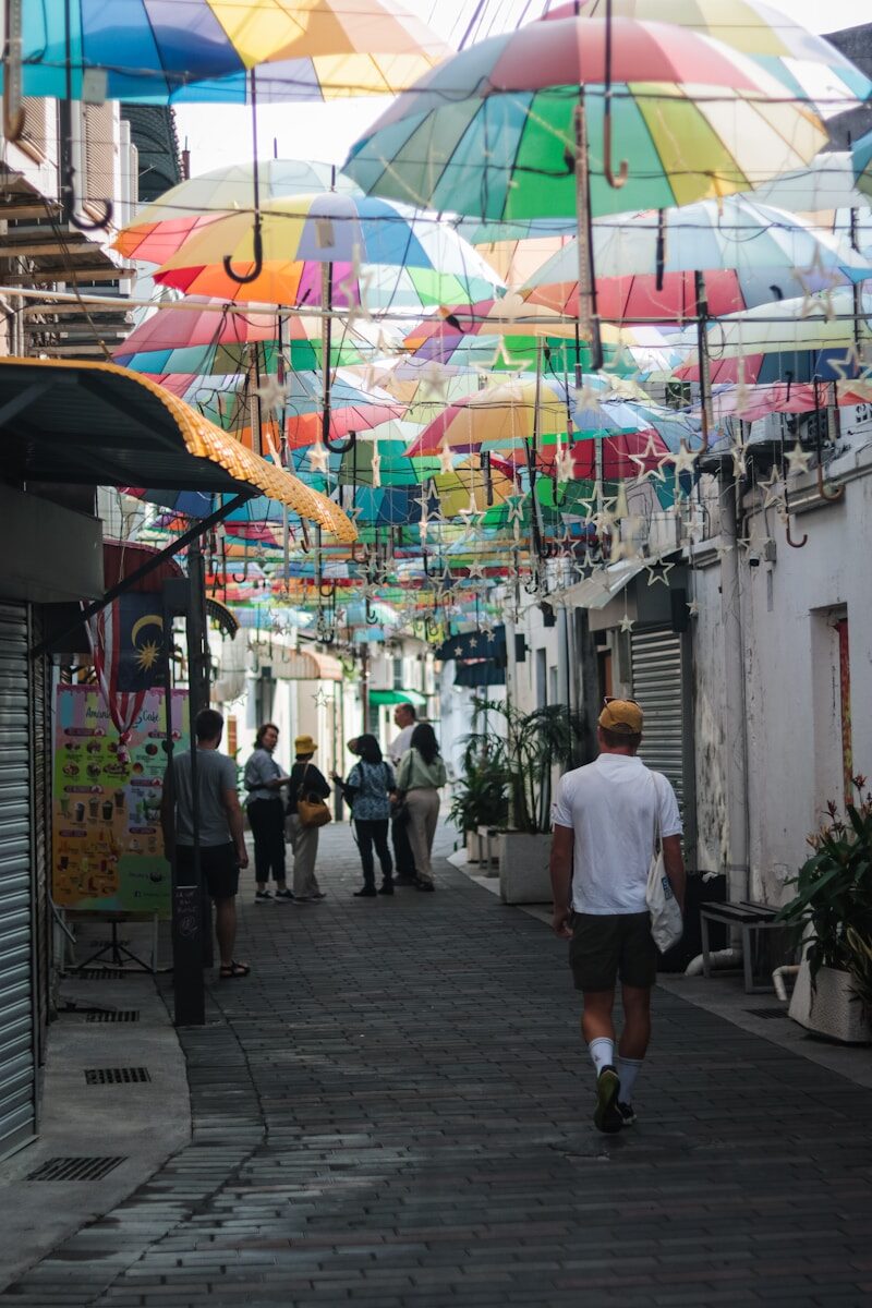 a group of people walking down a street under umbrellas